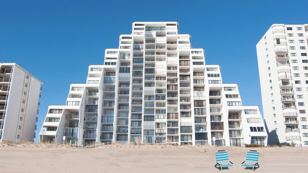 Ein mehrstöckiges Hotel mit modernem architektonischen Design, das Balkone und große Fenster zeigt.