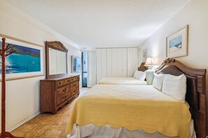 A bedroom with a bed, a dresser, a mirror, and a painting on the wall.