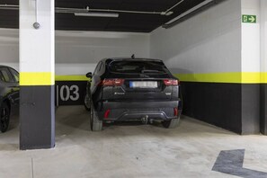A parking garage with a black SUV parked in a space marked with the number 03. - Luxury Apartment with Garden in Higueron (Fuengirola)