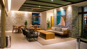 Una sala de estar moderna con pared de piedra, muebles de madera y un cuadro grande.