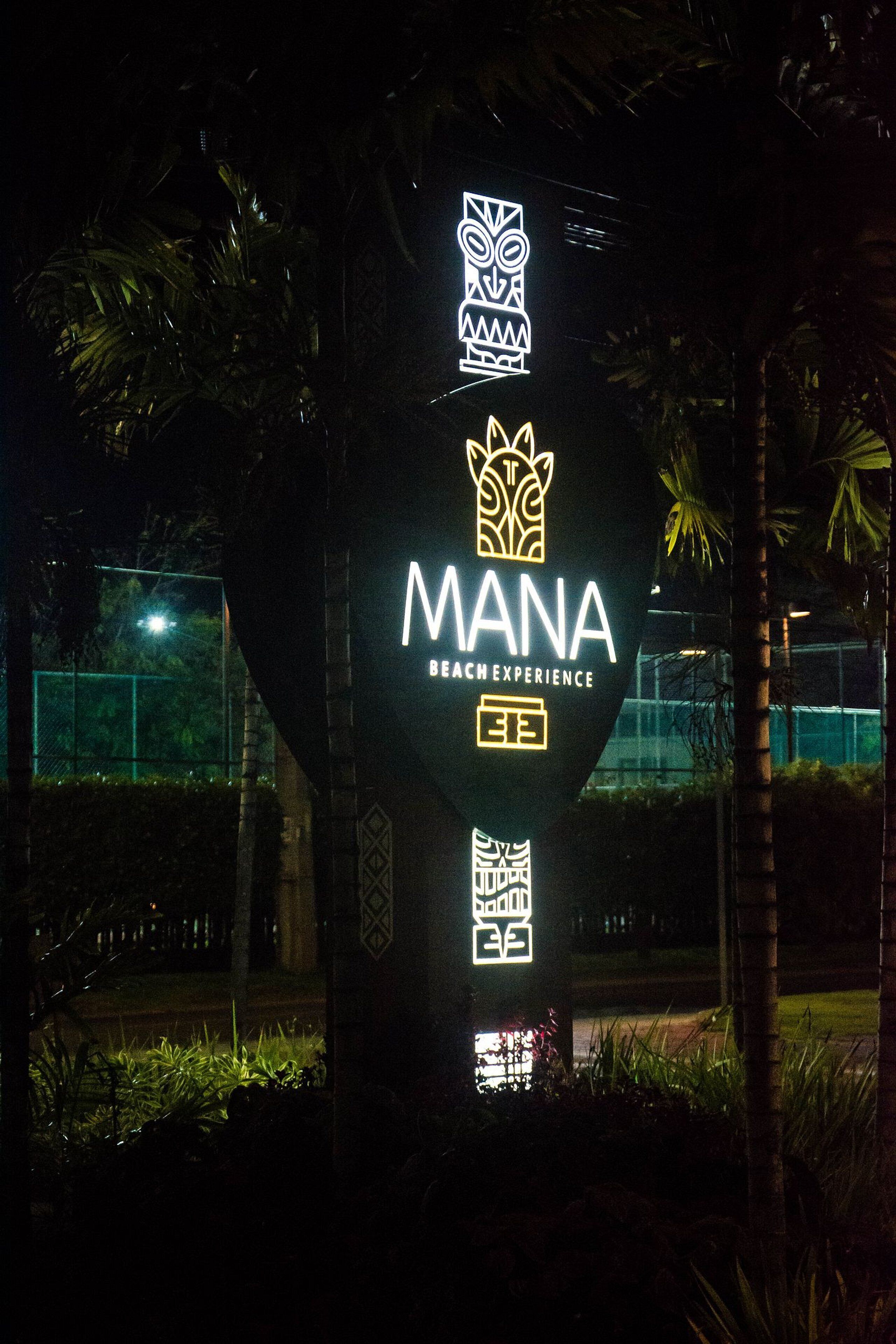 A sign with the word "MANA" and "BEACH EXPERIENCE" indicating a beachfront location.