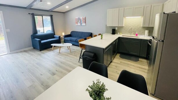 A modern kitchen with white cabinets, a central island, and a stainless steel refrigerator. - Sunny Getaway * 1BR condo close to the beach (A) (Myrtle Beach)