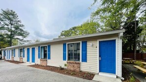 A row of mobile homes with blue doors and windows, arranged in a linear fashion along a gravel driveway. - Sunny Getaway * 1BR condo close to the beach (A) (Myrtle Beach)