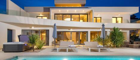 Relax by the inviting pool surrounded by lounge chairs and umbrellas.