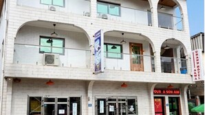 Un edificio de varios pisos con un restaurante en la planta baja y un letrero que dice 'OUR A SON AIM'.