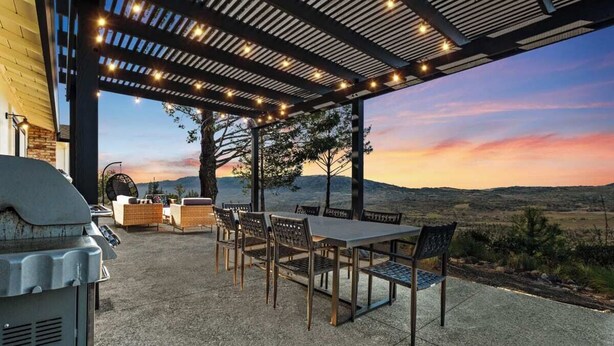 An outdoor patio with a grill, dining table, and chairs, overlooking a scenic landscape. - When in Glen | Panoramic View | Pool / Hot Tub (Glen Ellen)