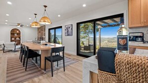 A modern kitchen with a large island, pendant lights, and a view of the outdoors. - When in Glen | Panoramic View | Pool / Hot Tub (Glen Ellen)