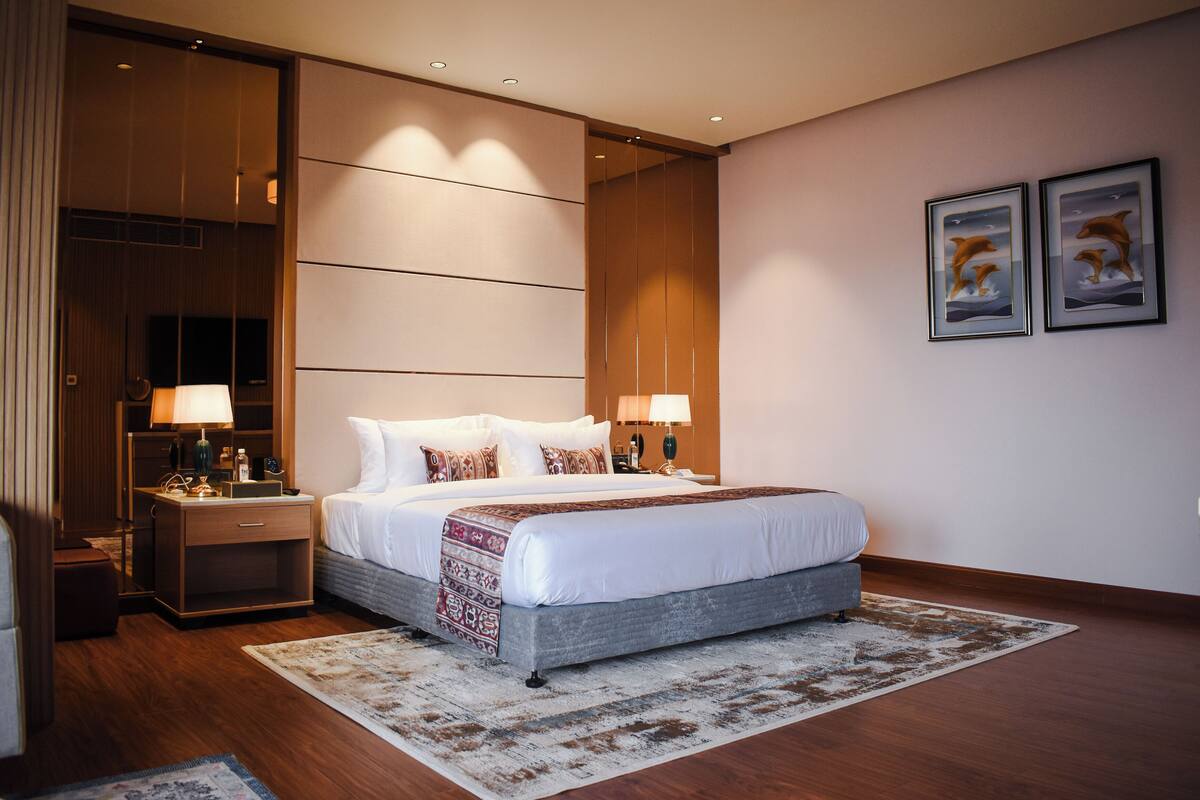Ein modernes Hotelzimmer mit einem großen Bett, Nachttischen und einem Beistelltisch.