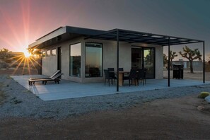 A modern house with a patio, a dining area, and a covered outdoor space. - Sundown Ridge Retreat by Homestead Modern (Yucca Valley)