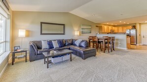 A modern living room with a leather sofa, a coffee table, and a dining area with a bar.