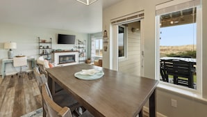 Een ruime keuken met een houten tafel, een open haard en uitzicht op de omgeving.
