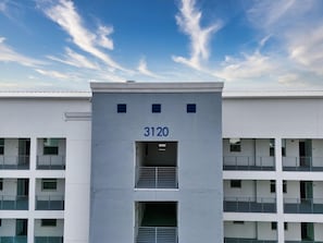 Un bâtiment moderne doté d’un toit plat, portant le numéro 3120, et offrant de nombreux balcons et fenêtres.