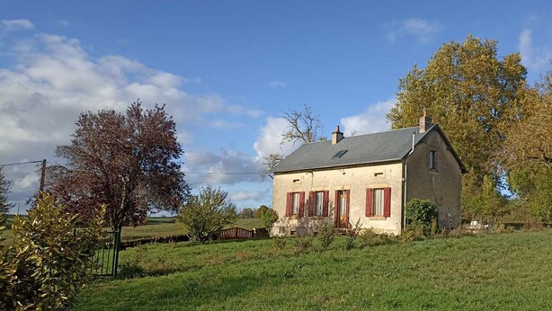 A two-story house with a sloped roof, a chimney, and a small porch with red shutters. - Gite Rural Entièrement Rénové, Près du Canal du Nivernais Avec Très Belle vue (saint gratien savigny)