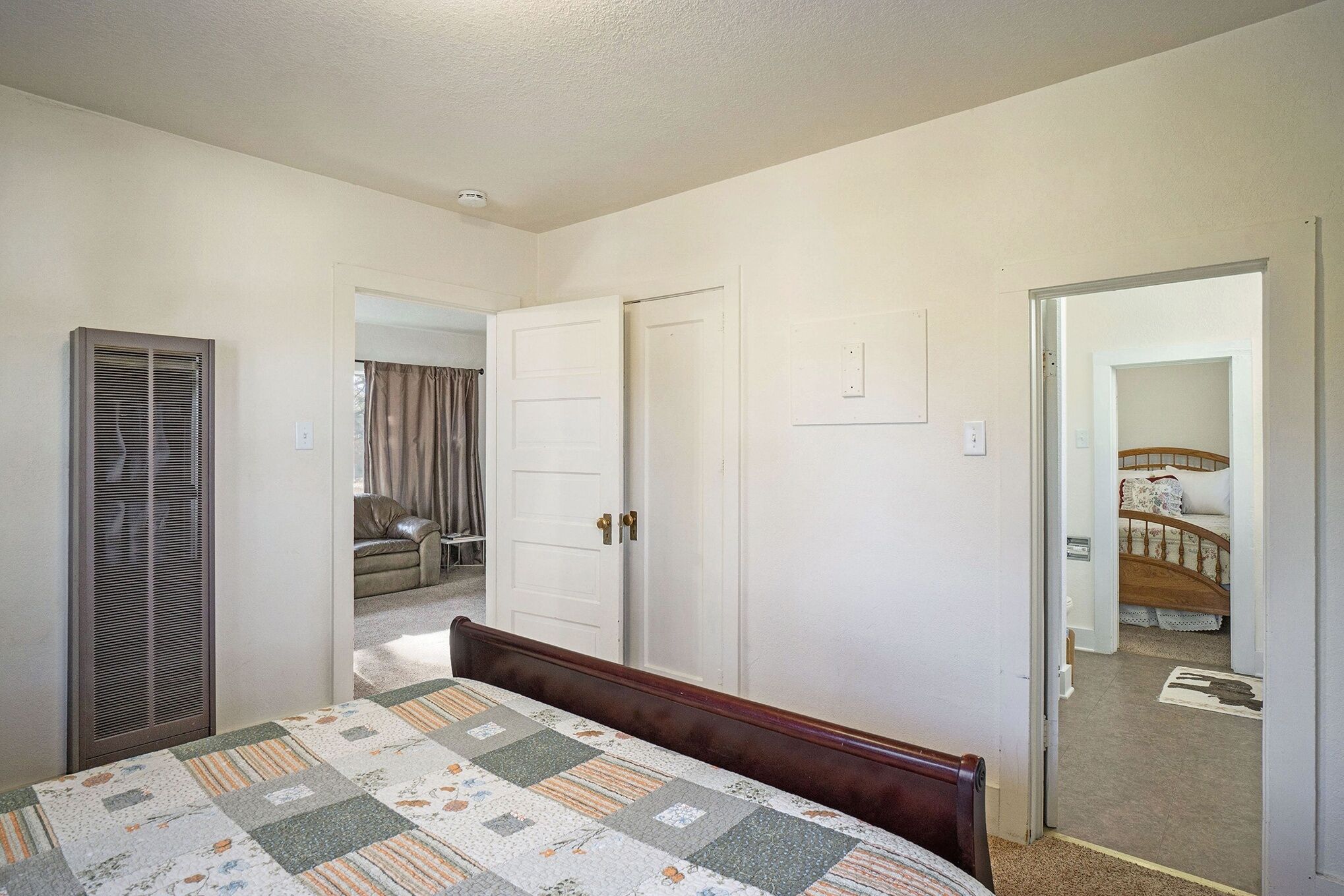 Un dormitorio con una cama, un armario y una puerta que da a un baño.