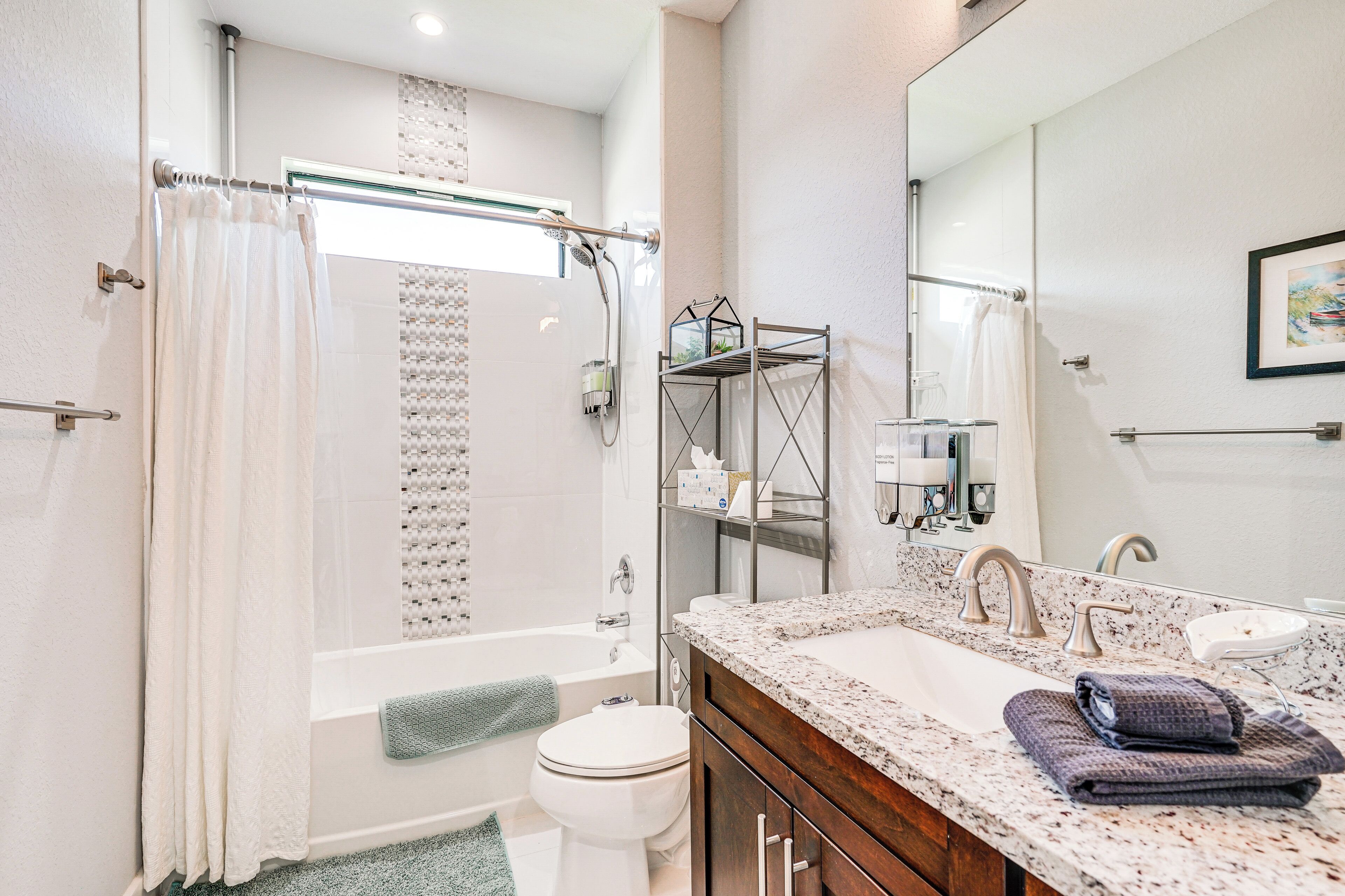 A modern bathroom with a bathtub, toilet, and sink.