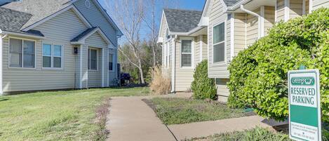 A residential area with a 'Greenbush Reserved Parking' sign, houses with sloped roofs, and a well-maintained lawn.