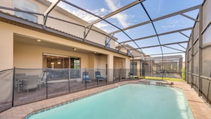 Une piscine intérieure dotée d’une paroi vitrée, de chaises longues et d’un espace patio.