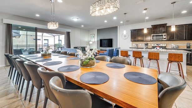 Un espace repas moderne avec une longue table en bois, plusieurs chaises et un élément décoratif central.