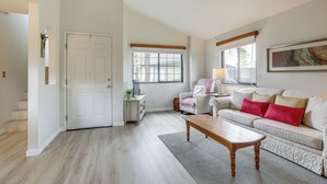 Ein Wohnzimmer mit Sofa, Couchtisch, Tür und Fenster.
