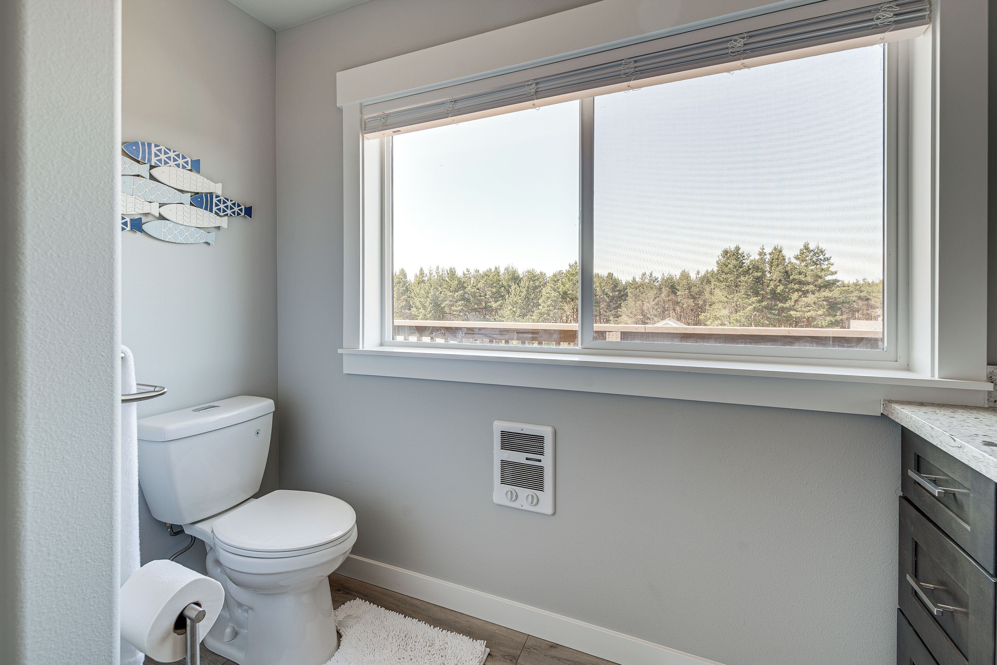 Baño con inodoro, ventana y rejilla de ventilación.