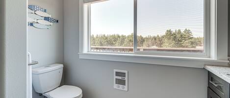Baño con inodoro, ventana y rejilla de ventilación.