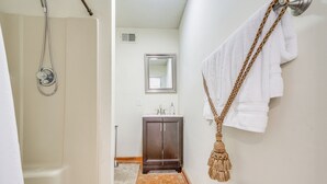 A bathroom with a shower, a sink, and a mirror.
