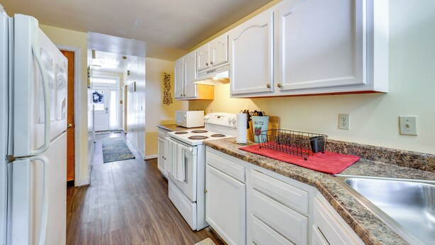 A kitchen with white cabinets, a stainless steel sink, and a red mat on the countertop. - Cozy East Pittsburgh Home - 7 Mi to Frick Park! (East Pittsburgh)