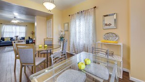 A dining area with a glass table, chairs, and a white shelf with decorative items. - Cozy East Pittsburgh Home - 7 Mi to Frick Park! (East Pittsburgh)