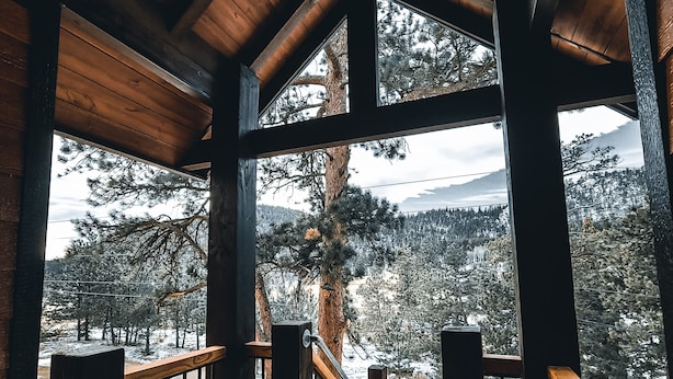 Eine Holterrasse mit Blick auf schneebedeckte Bäume und Berge.