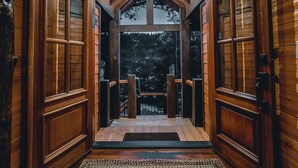 Ein Holzinnenraum mit einer zentralen Treppe, die zu einem Balkon führt.