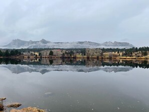 A calm lake with a reflection of trees and mountains in the background. - Longs Peak Cabin - Monthly Long-term Vacation Rental 30+ Days -- Estes Park 3 Bedroom Cabin by RedAwning (Estes Park)