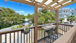 A wooden deck with a pergola, outdoor seating, and a view of a residential area with houses and trees. - 30a Hideaway 2 Bedroom Townhouse by RedAwning (Panama City Beach)