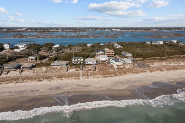Een kustwoongebied met huizen in de buurt van het strand en een groot waterlichaam.