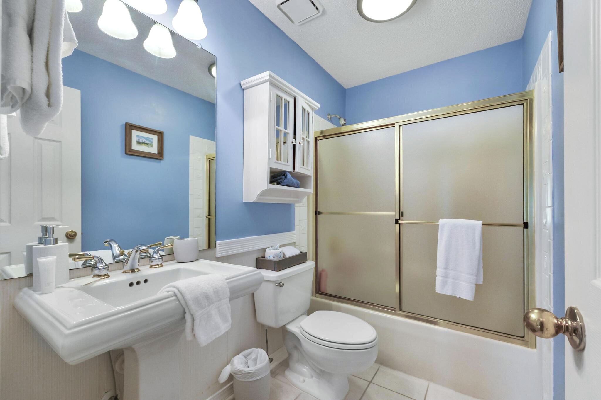 A bathroom with a sink, toilet, and shower.