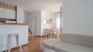 En moderne lejlighed med et tekøkken, et spiseområde og en opholdsstue med en sofa.