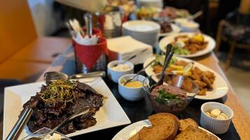 A buffet table with various dishes including meat, bread, and vegetables.