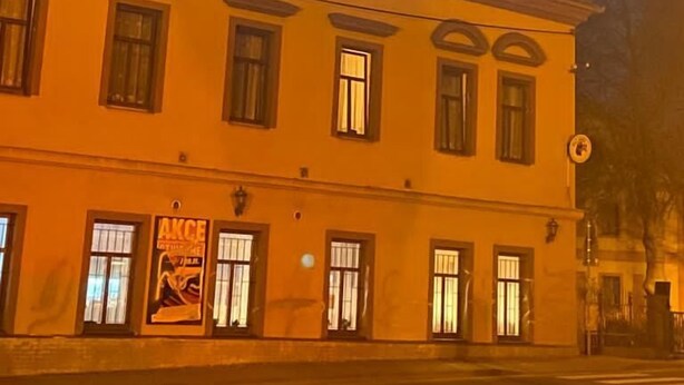 A two-story building with multiple windows and a sign on the ground floor. - Malý Janek z Jinec - brewery (Jince)