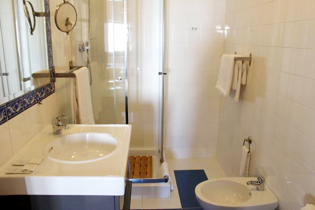 A bathroom with two sinks, a shower, and a mirror.
