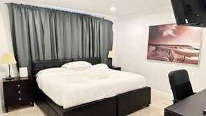 Une chambre moderne avec un grand lit, un bureau et une chaise.