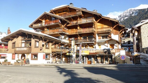 A multi-story wooden building with balconies, a ski lift, and a mountain backdrop. - 3rd floor, parking, tv, ski locker, 38m², Les Contamines-Montjoie (Les Contamines-Montjoie)