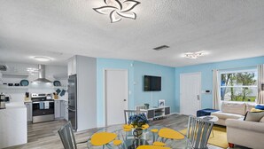 A modern kitchen with white cabinets, a stainless steel refrigerator, and a built-in oven.