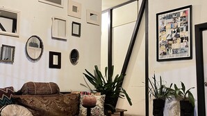 Una sala de estar con un sofá, una mesa de centro y varias fotografías enmarcadas en la pared.