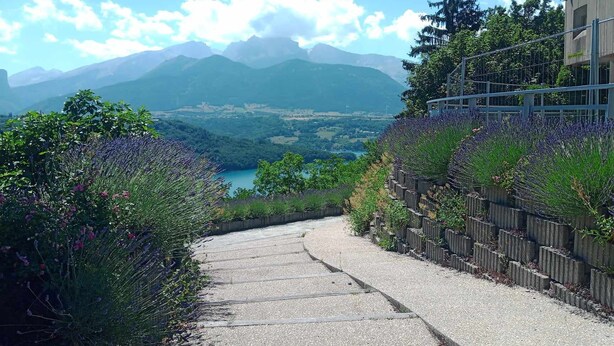A paved pathway leading to a scenic overlook with mountains in the background.