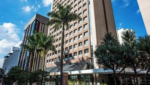 A tall hotel with a modern design, featuring a prominent entrance and multiple floors. - Studio Living Mercure Liberdade (São Paulo)