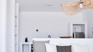 Uma sala de estar moderna e minimalista, com um sofá branco, uma mesa de centro e um lustre.