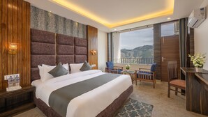 A modern hotel room with a large bed, a desk, and a balcony with a view. - Manaw Valley Resort (Shimla)