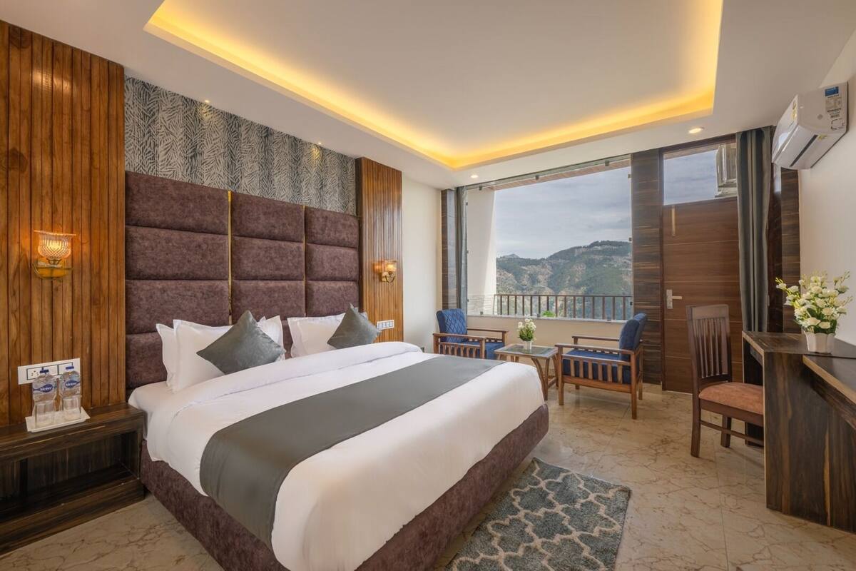 Ein modernes Hotelzimmer mit einem großen Bett, einem Schreibtisch und einem Balkon mit Blick.