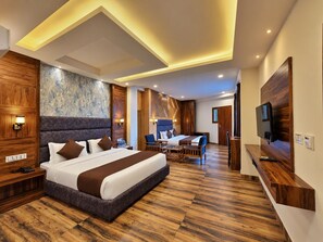 A modern hotel room with a large bed, a desk, and a TV.