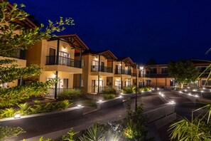 A hotel with multiple balconies, outdoor lighting, and landscaped areas. - The Fern Wisteria Resort Dhari (Dhari)