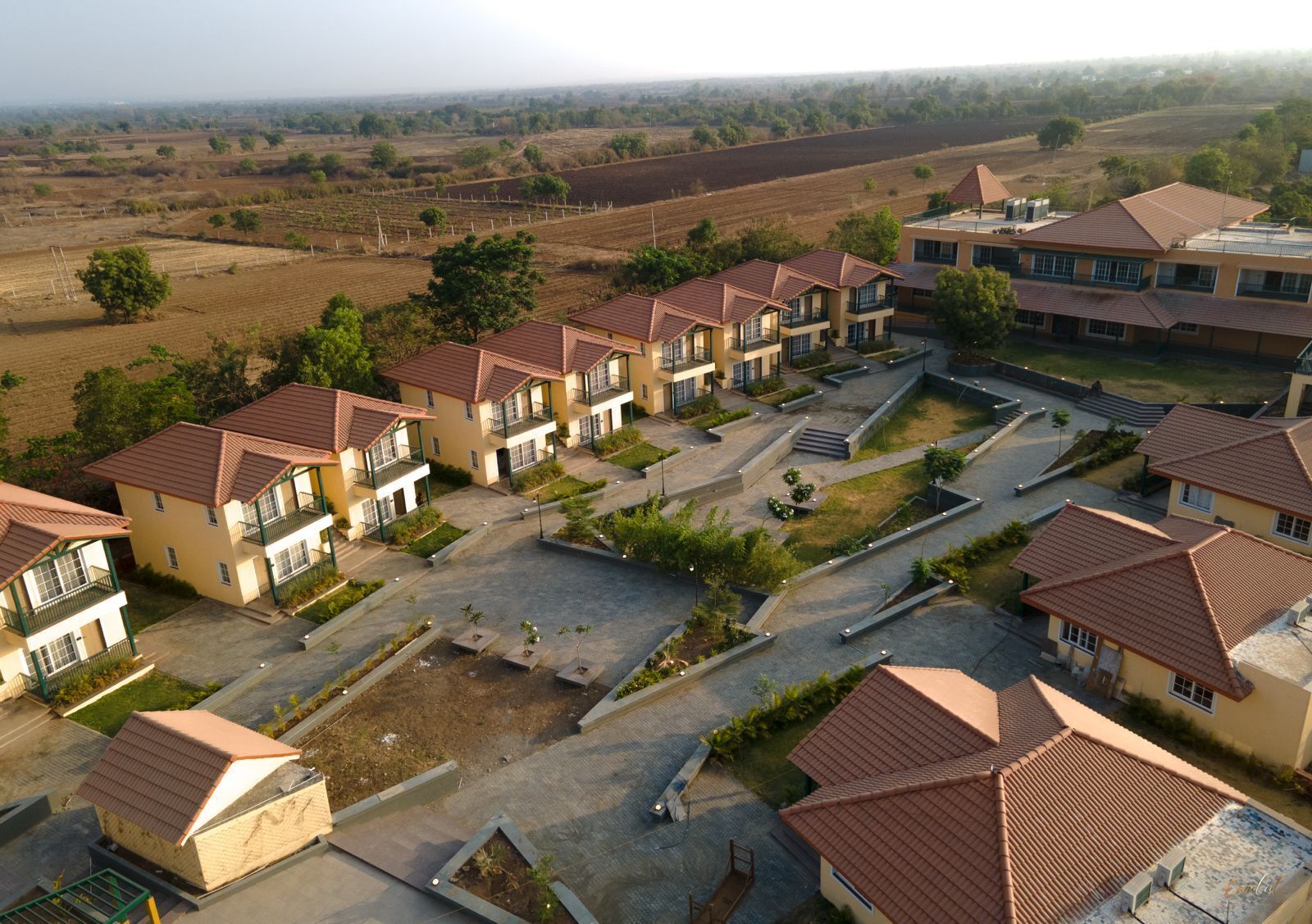 Un barrio residencial con varias casas de dos pisos, techos de tejas rojas y balcones.